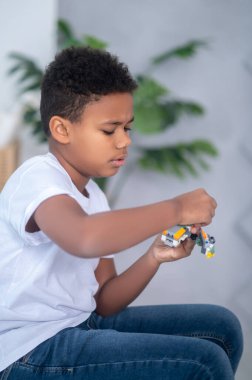 Esmer tenli bir çocuk işin içinde gibi görünüyor.