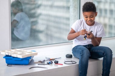 Esmer tenli bir çocuk işin içinde gibi görünüyor.