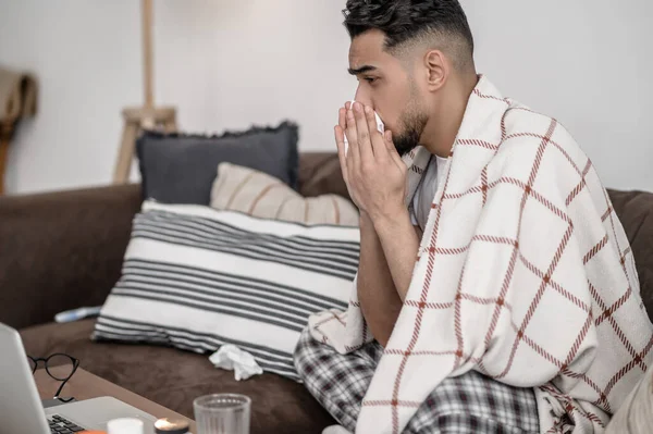 A dark-haired man having a flue and cleaning his nose — Foto de Stock