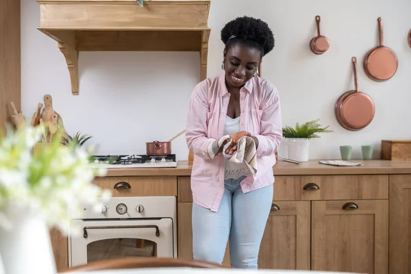 Pembe elbiseli, elleri kuruyan Afrikalı bir kadın.
