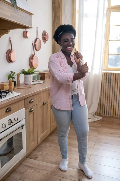 Gülümseyen Afrikalı kadın şarkı söylüyor ve bakıyor.