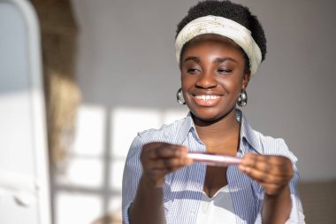 Ellerinde rimel tutan memnun Afrikalı kadın.