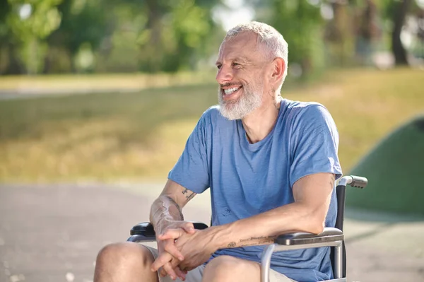 Un om cu părul gri într-un scaun cu rotile în parc — Fotografie, imagine de stoc