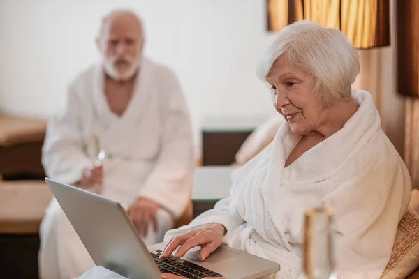 Egy idősebb pár keres valamit az interneten, és érdeklődést mutat. — Stock Fotó