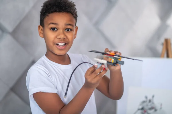 一个可爱的孩子在忙着组装玩具直升机零件 — 图库照片