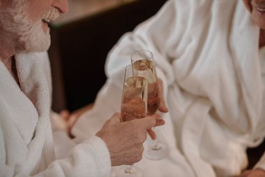 Şarap içen ve mutlu görünen yaşlı bir çift.