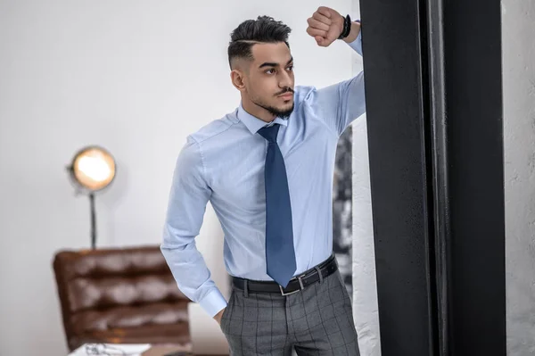 Um homem de negócios elegante em uma camisa azul e gravata de pé — Fotografia de Stock
