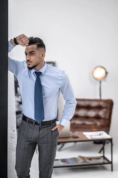 A stylish businessman in a blue shirt and tie standing — Foto de Stock