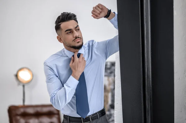 Un hombre de negocios con estilo en una camisa azul y corbata de pie — Foto de Stock