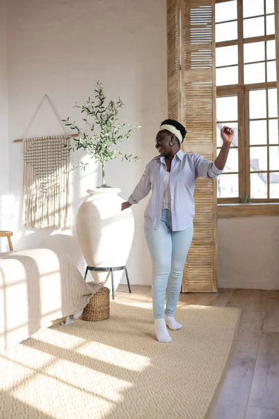 Afrikansk kvinna i ljusa kläder tillbringar tid hemma — Stockfoto