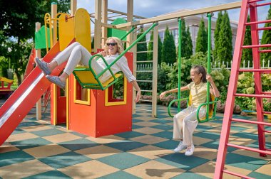 Anne ve kızı salıncakta harika hissediyorlar.