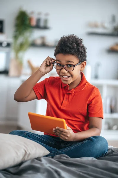 Boy in orange tshirt looking excited while watching something online — Foto de Stock
