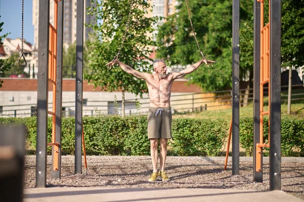 Ein Mann in kurzen Hosen beim Training auf einem Sportplatz im Park — Stockfoto