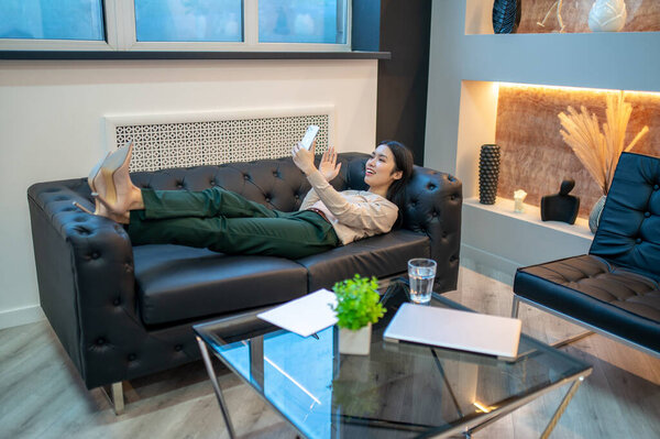 Радостная предпринимательница в чате с кем-то по скайпу