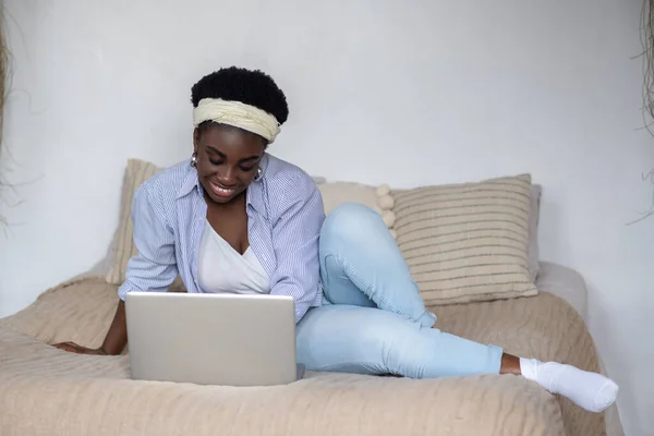 Afroamerikansk kvinna chattar på internet och ser involverad ut — Stockfoto