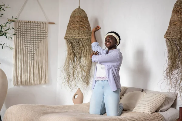 Африканская женщина в спальне с этническим интерьером — стоковое фото