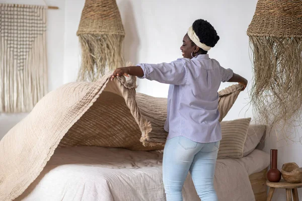 African woman in a bedroom with ethnic interior — Stockfoto