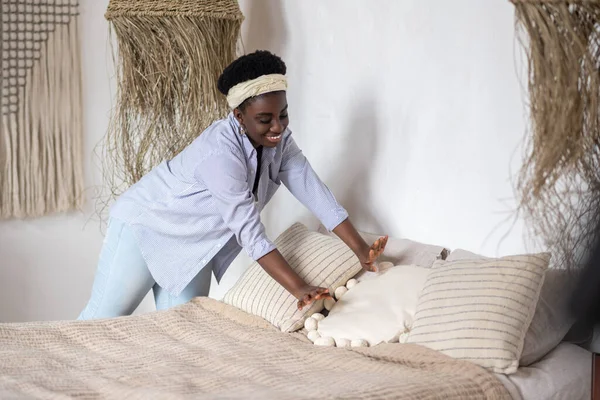 Mörkhårig kvinna bäddar i sovrummet — Stockfoto