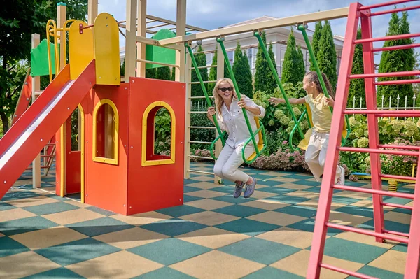 Anne ve kızı salıncakta harika hissediyorlar.