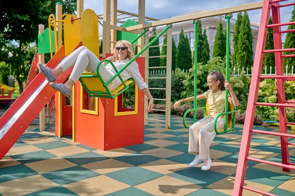 Anne ve kızı salıncakta harika hissediyorlar.