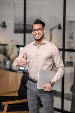 Dizüstü bilgisayarı olan genç bir iş adamı.