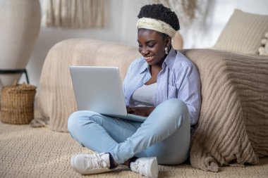 Dark-skinned smiling woman witha laptop