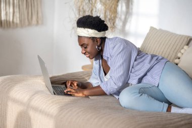 African american woman chatting on internet and looking interested