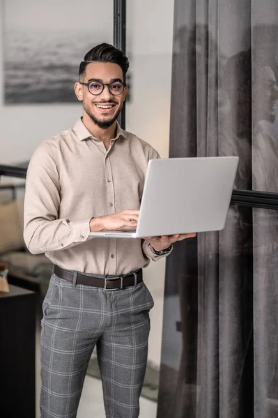 Mladý byznysmen s laptopem, který vypadá jako cotented — Stock fotografie