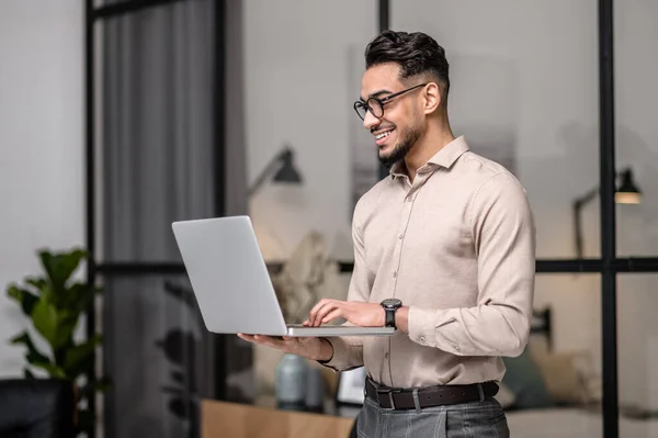 A young businessman with a laptop looking cotented — 스톡 사진