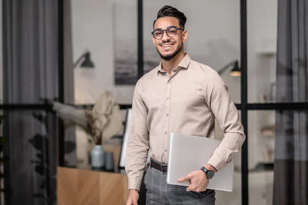 Un jeune homme d'affaires avec un ordinateur portable à la recherche cotented — Photo