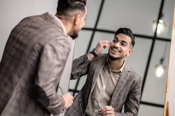 Aynaya bakan yakışıklı, zarif bir genç adam.