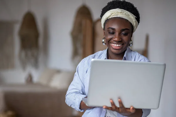 Dark-skinned smiling woman witha laptop — Photo