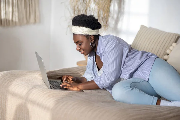 African american woman chatting on internet and looking interested — Photo