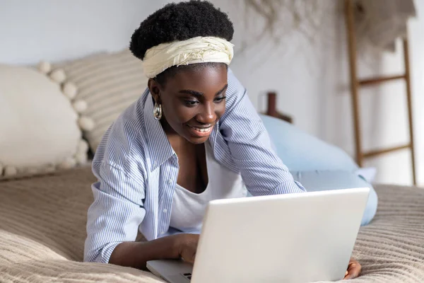 African american woman chatting on internet and looking involved — Stockfoto