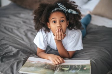 A sweet girl showing silence sign and looking excited