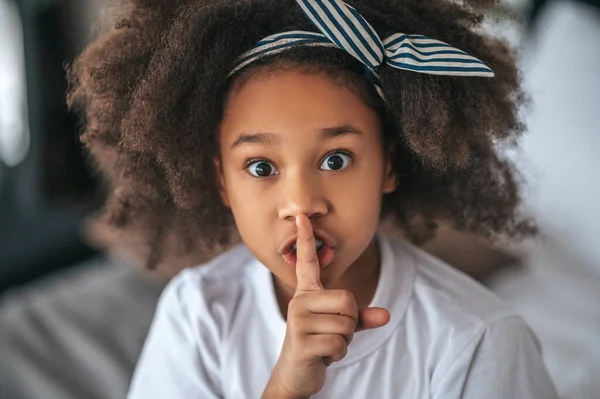 Ένα γλυκό κορίτσι που δείχνει το σημάδι σιωπής και δείχνει ενθουσιασμένη. — Φωτογραφία Αρχείου
