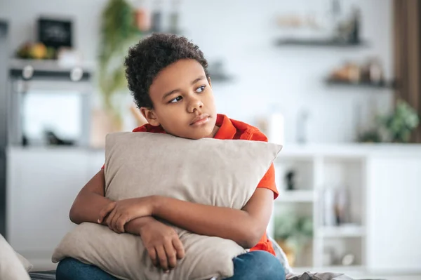 A boy with a pillow in hands looking upset — Stock fotografie
