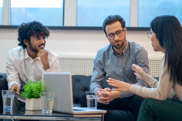 Three company workers holding a group discussion — Foto de Stock