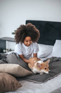 Şirin bir çocuk köpek yavrusuyla oynuyor ve heyecanlanıyor.