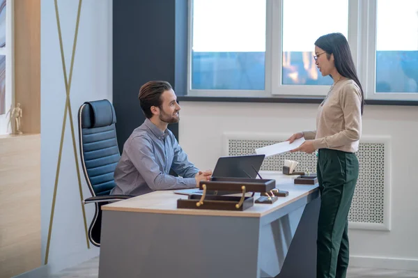 Asistente entregando documentos a su jefe en su oficina — Foto de Stock