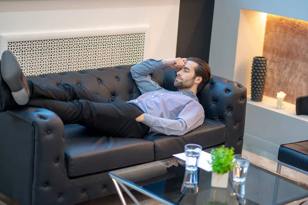 Exhausted businessman resting in his company office — Stockfoto