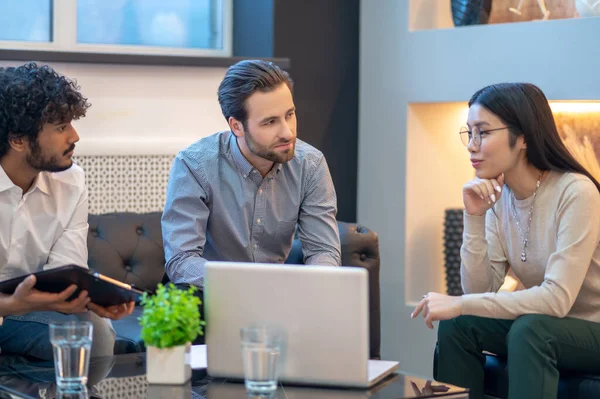 Group of three young entrepreneurs conducting talks — Stock Fotó