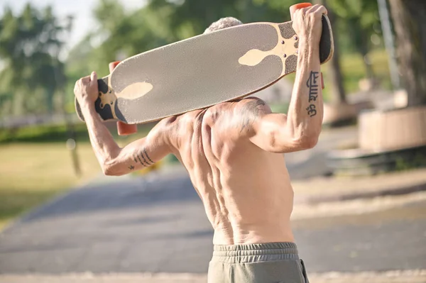滑板手拿着滑板的半裸体滑板手 — 图库照片