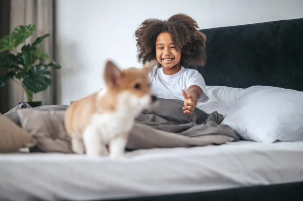 A cute kid playing with a puppy and feeling excited — Stockfoto