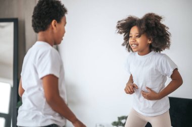 İki kardeş birlikte oynuyor ve heyecanlı görünüyorlar.