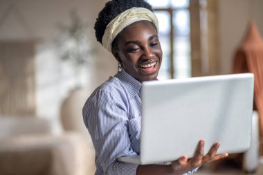 Dark-skinned smiling woman witha laptop