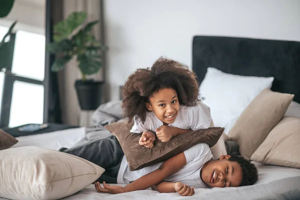 Two kids playing on the bed in the bedroom — Stock Photo, Image