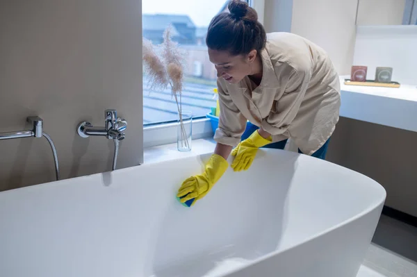 Evde temizlik yapan ve banyoyu dezenfekte eden bir kadın. — Stok fotoğraf