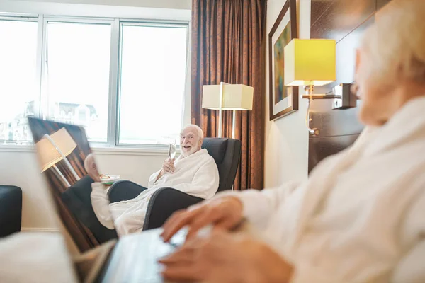 Elderly woman in a hotel room with a laptop — Fotografia de Stock