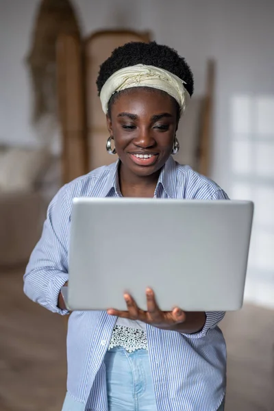Dark-skinned smiling woman witha laptop — Photo